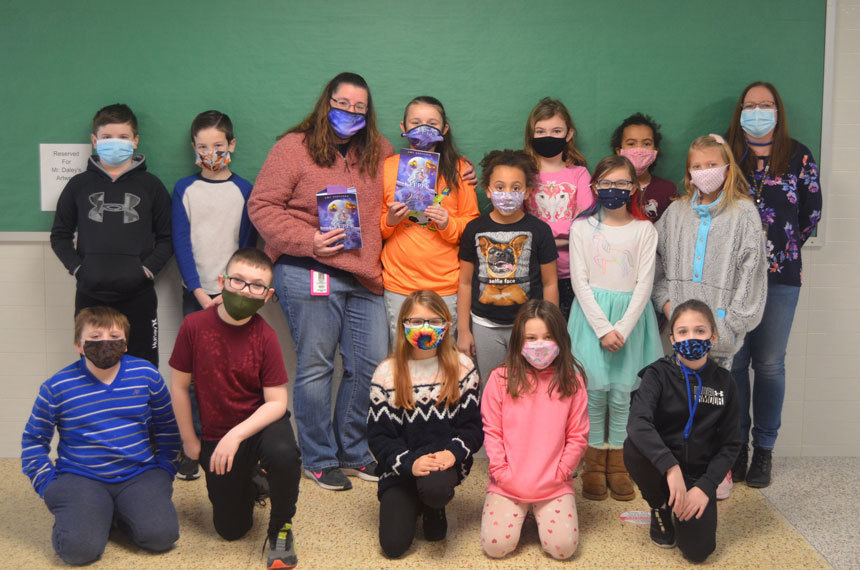 classroom of masked students standing and kneeling