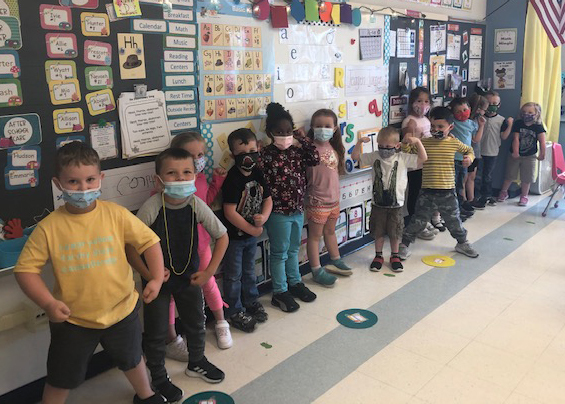 preschoolers lined up in front of bulletin board
