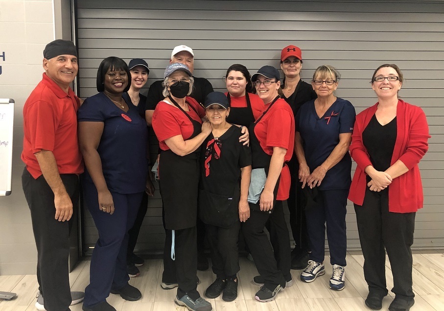 11 people standing, wearing red and black