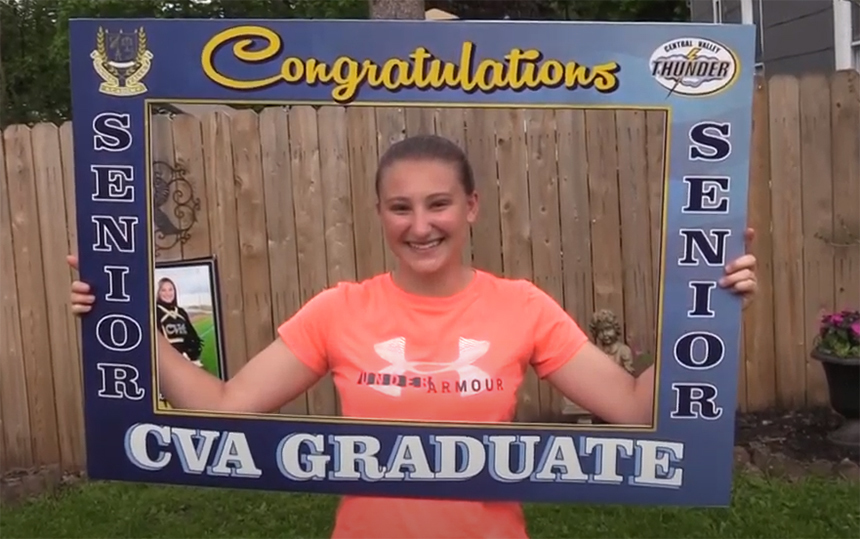 Girl smiling holding giant Congrats graduation picture frame