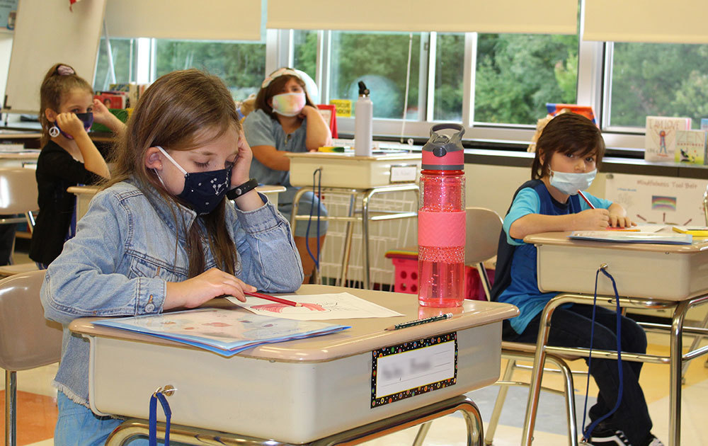 four students seated, classroom, desks, windows