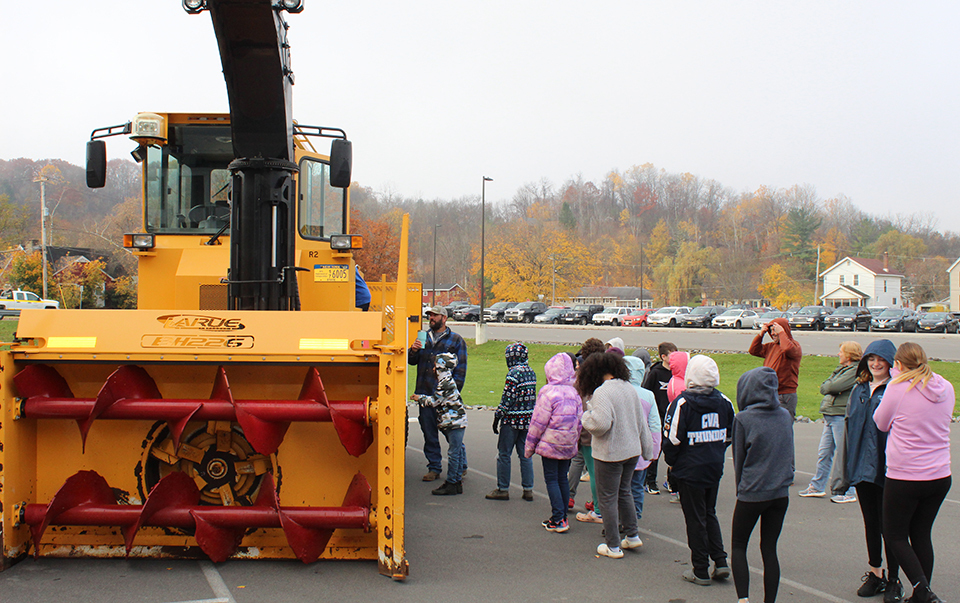 giant highway snowblower. students, outside, parking lot, cars