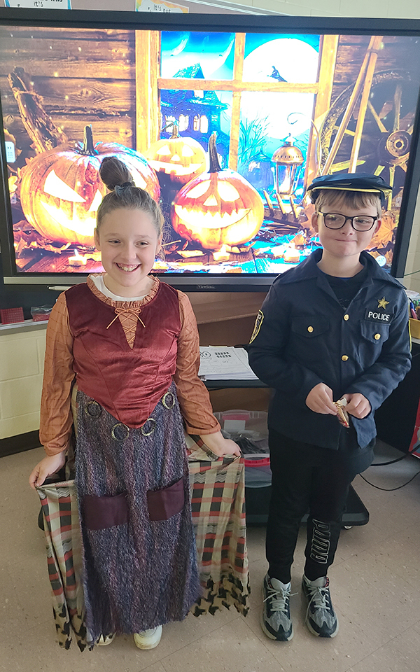 2 students in Halloween costumes, classrooms, bulletin board