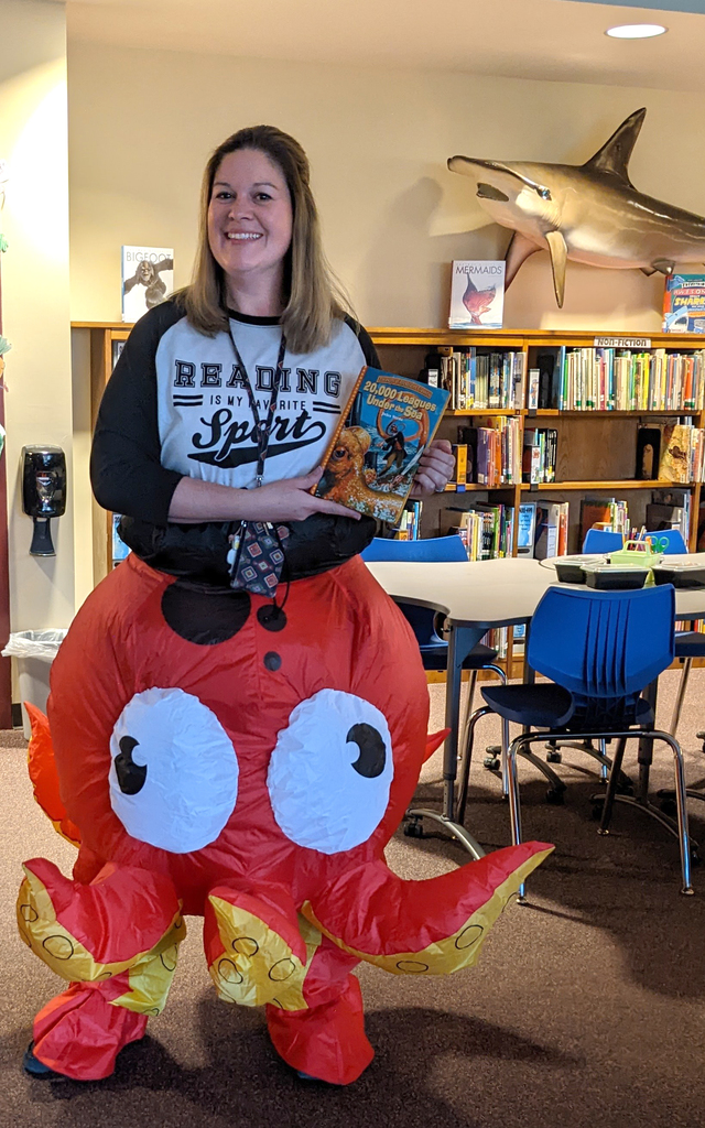 adult in octopus costume holding a book, library, books, shelves