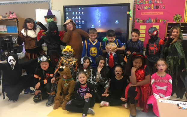 group of students in Halloween costumes, classroom, bulletin board