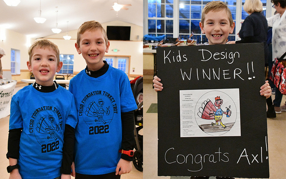 Two boys wearing matching t-shirts, one boy with congratulations poster