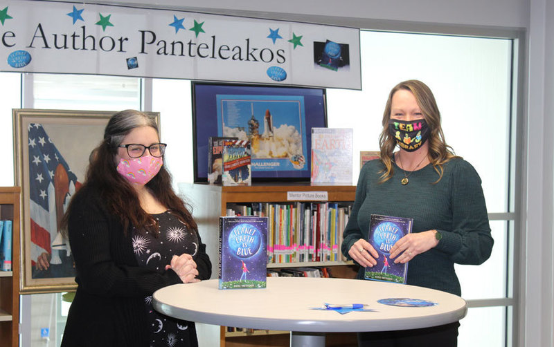 two women standing at round table in library