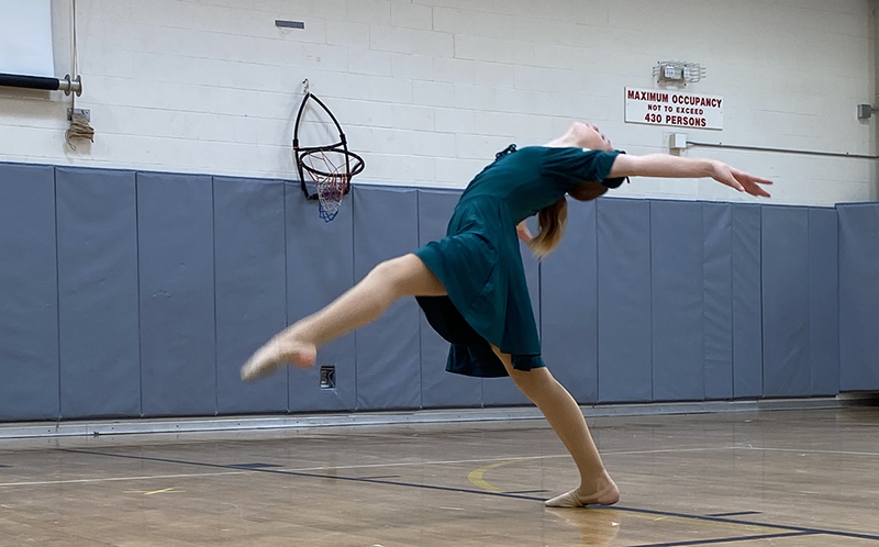 lone dancer leaning backward in gym