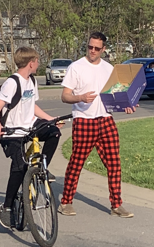 man holding box, boy on bike, outdoors, cars