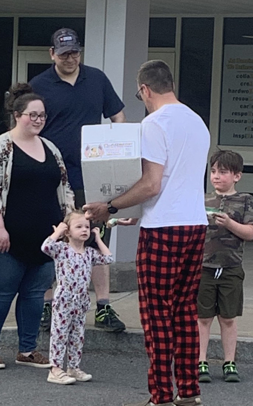 man with box, two adults, two children, outdoors, school