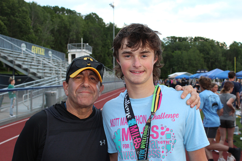 2 men outdoors, trees, running track