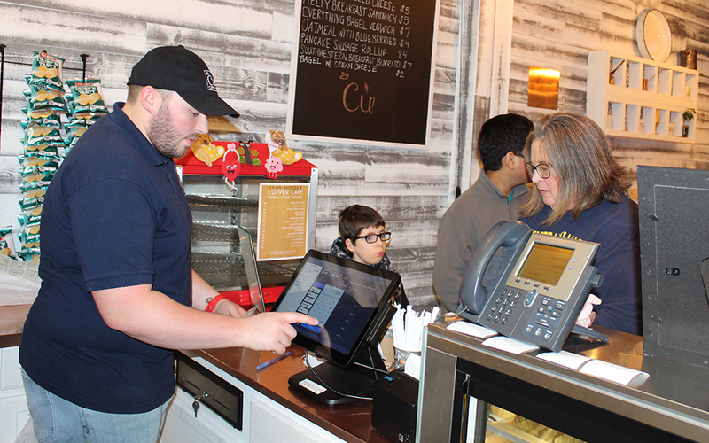 cashier waiting on woman and student at counter