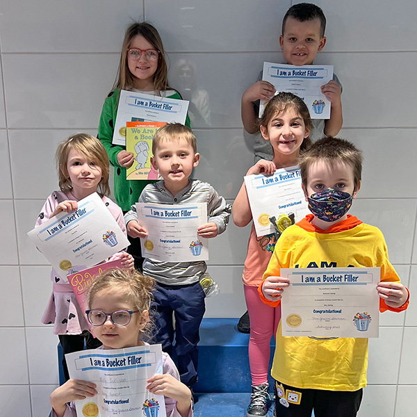 smiling students holding certificates