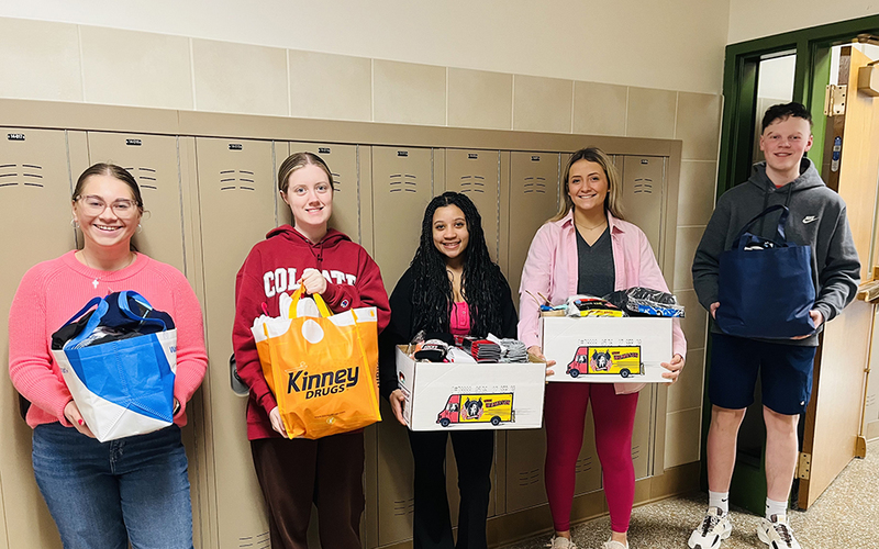 5 students, hallway, lockers, four holding boxes