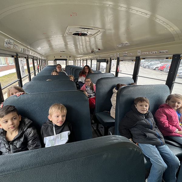 students seated and smiling on school bus