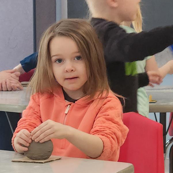 closeup of young girl handling a ball of clay