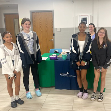 5 people standing near table, door hallway