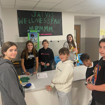 7 students standing around table, sign saying Jarvis Wellness Day